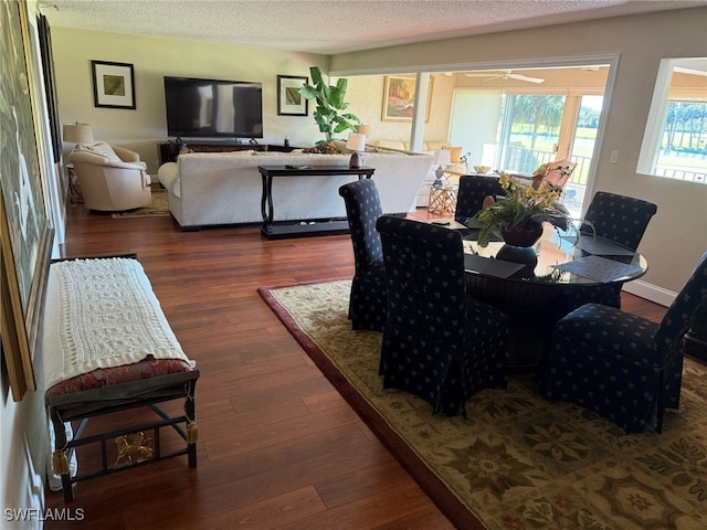 dining space with a textured ceiling, a ceiling fan, baseboards, and wood finished floors