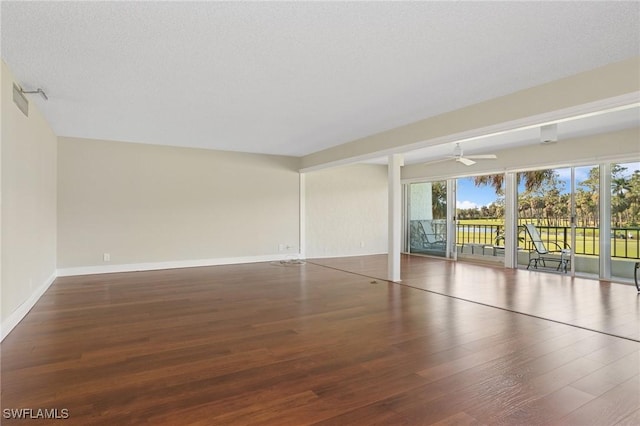 spare room featuring baseboards, a textured ceiling, wood finished floors, and a ceiling fan