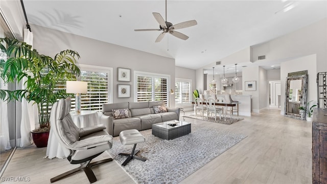 living room featuring high vaulted ceiling, light hardwood / wood-style flooring, and ceiling fan