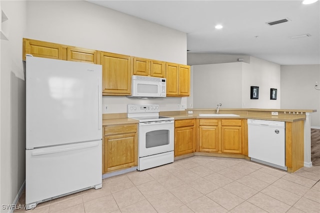 kitchen with kitchen peninsula, white appliances, and sink