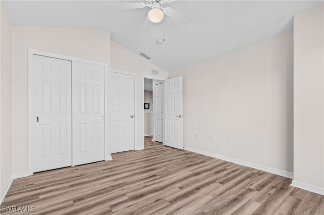 unfurnished bedroom with ceiling fan, a closet, light wood-type flooring, and lofted ceiling