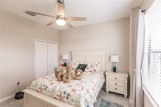 bedroom with ceiling fan, light tile patterned floors, and a closet