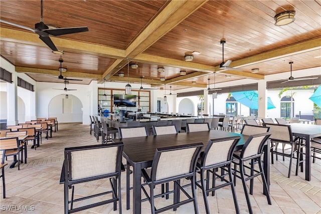 dining room featuring beamed ceiling, ceiling fan, and wooden ceiling