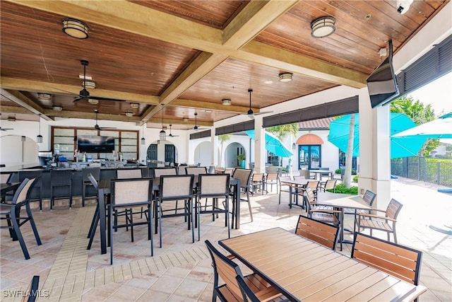 view of patio featuring ceiling fan and exterior bar