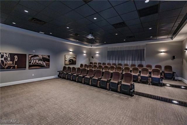 carpeted home theater featuring a drop ceiling