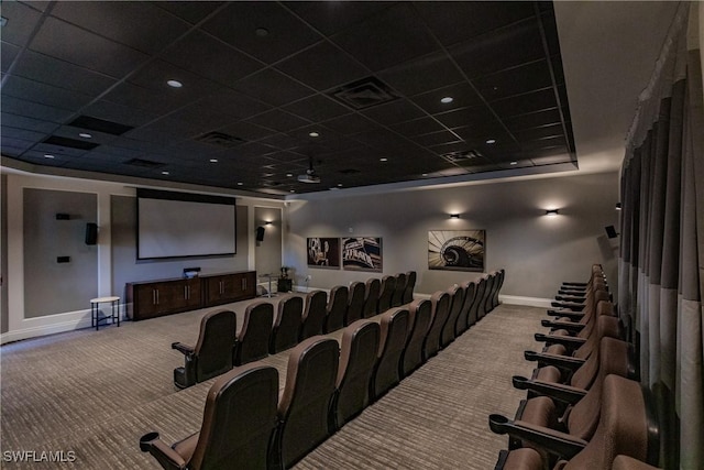 carpeted home theater room with a tray ceiling and a drop ceiling