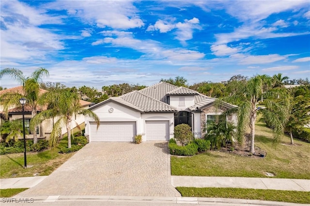 11973 Bay Oak Dr, Fort Myers, FL 33913 - view of front of property featuring a garage, decorative driveway, stucco siding, a front lawn, and a tile roof