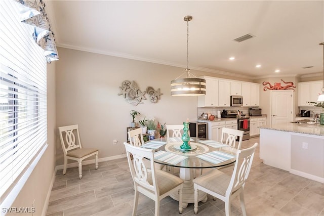 dining room featuring wine cooler, crown molding, and sink