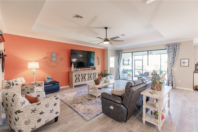 living room featuring ceiling fan, crown molding, and a tray ceiling