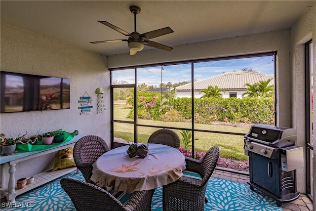 sunroom featuring ceiling fan