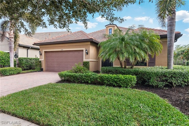 7370 Mockingbird Ct, Naples, FL 34114 - view of front of house featuring stucco siding, driveway, a front lawn, a tile roof, and a garage