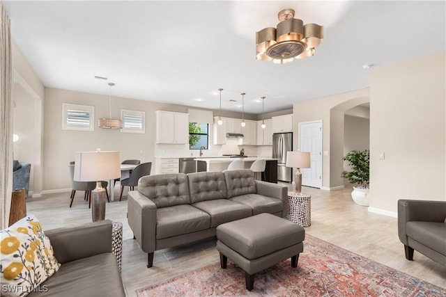 living room featuring sink and light hardwood / wood-style flooring