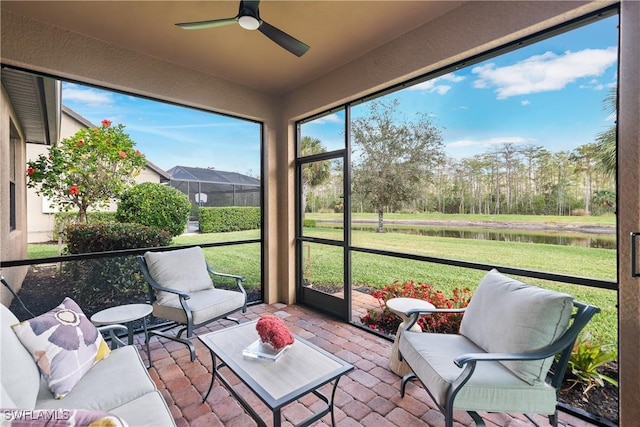 sunroom / solarium with a water view and ceiling fan