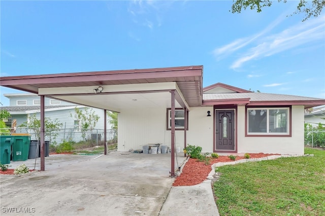 view of front of house featuring a carport and a front lawn