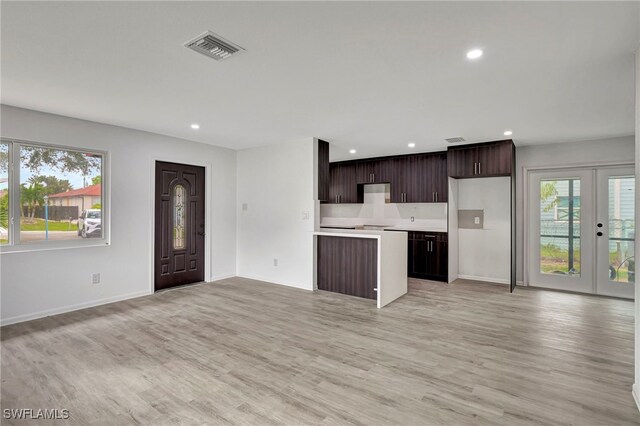 kitchen featuring light wood-type flooring, french doors, and dark brown cabinets