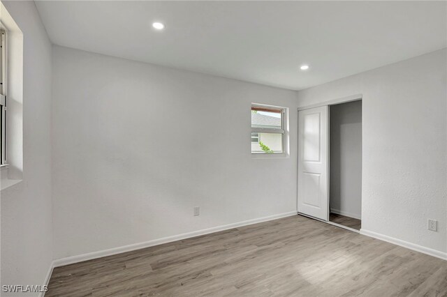 unfurnished bedroom with a closet and light hardwood / wood-style floors