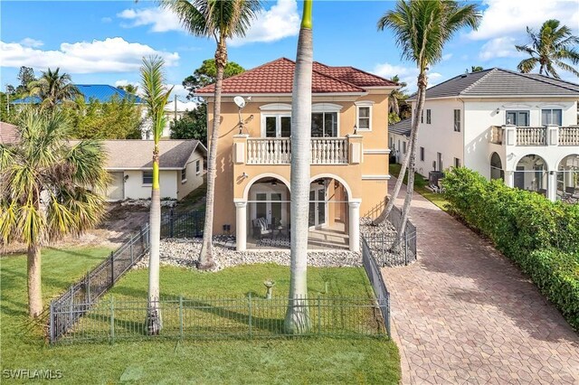 view of front of house with a front lawn, french doors, and a balcony