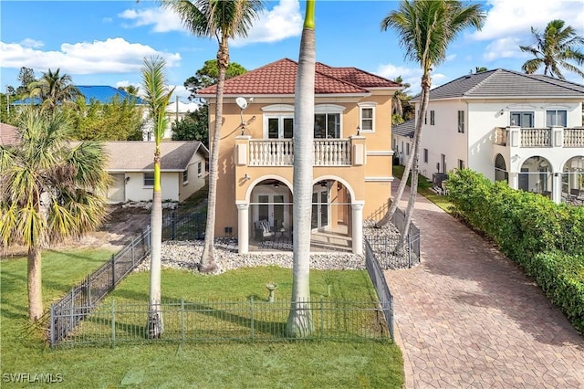 view of front of property with french doors, a balcony, and a front lawn