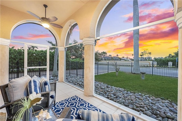 patio terrace at dusk with a yard and ceiling fan