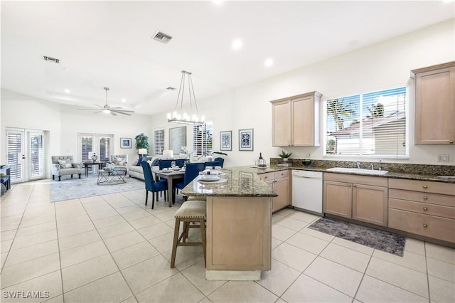 kitchen featuring french doors, light tile patterned flooring, white dishwasher, a kitchen breakfast bar, and kitchen peninsula