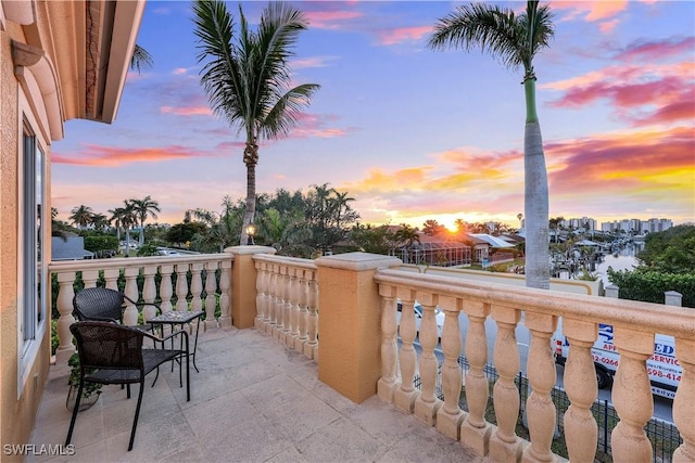 balcony at dusk with a porch and a water view