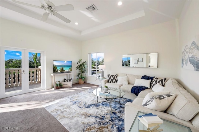 carpeted living room featuring french doors, ceiling fan, and a tray ceiling