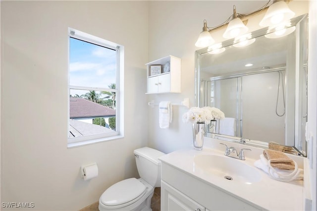 bathroom with vanity, a shower with shower door, and toilet