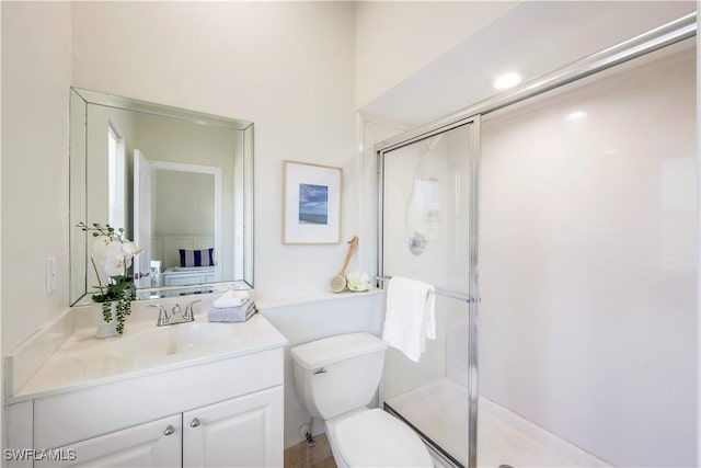 bathroom featuring vanity, toilet, and an enclosed shower