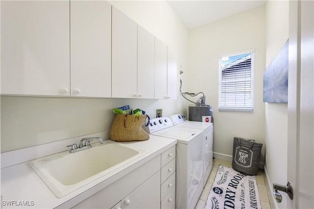 laundry area featuring light tile patterned flooring, sink, gas water heater, cabinets, and separate washer and dryer