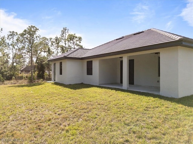 rear view of property with a yard and a patio area