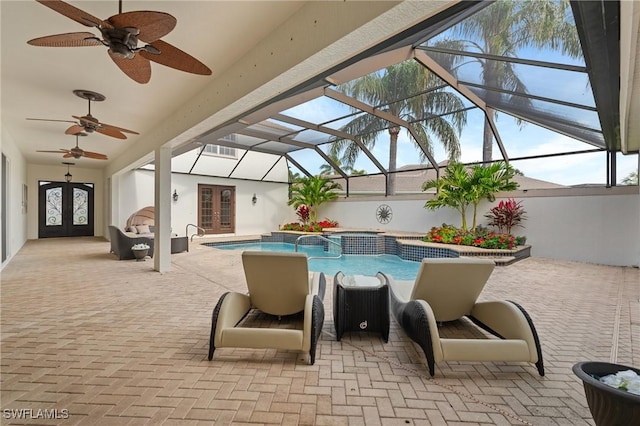 view of pool with a patio, french doors, pool water feature, and glass enclosure