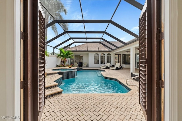 view of pool featuring an in ground hot tub, a lanai, and a patio