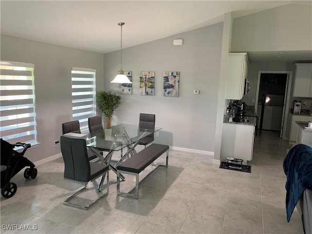 tiled dining area with vaulted ceiling