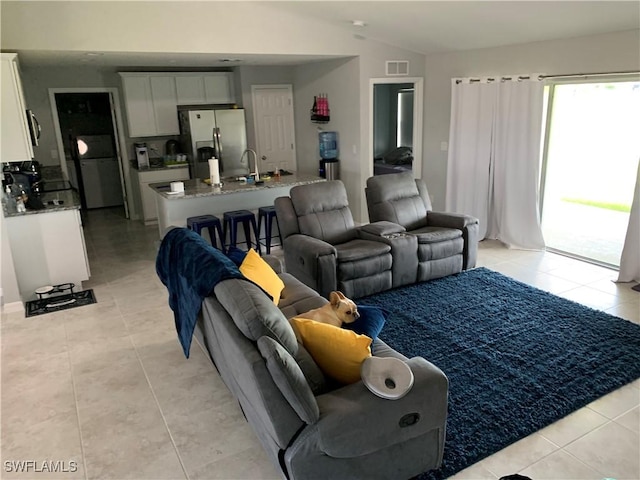 tiled living room featuring vaulted ceiling