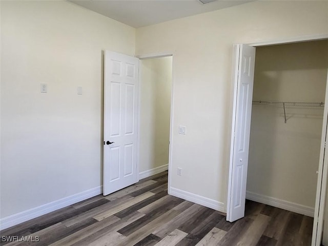 unfurnished bedroom featuring a closet and dark hardwood / wood-style floors