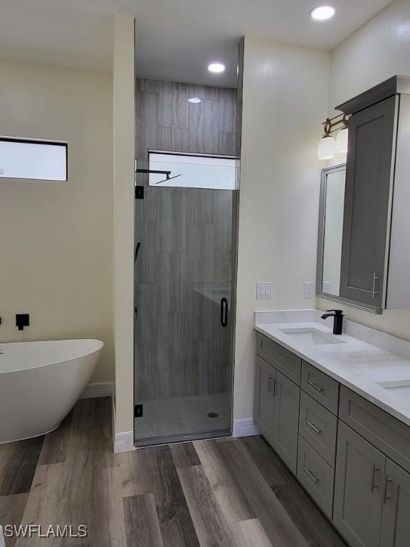 bathroom with vanity, wood-type flooring, and plus walk in shower