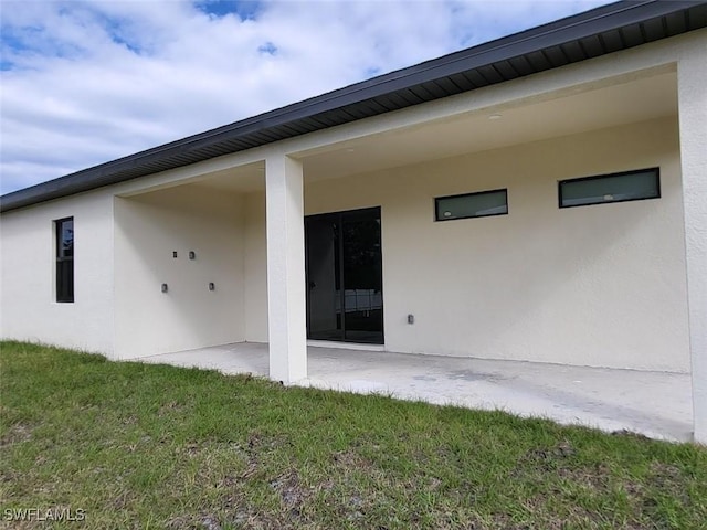 back of property featuring a yard and a patio