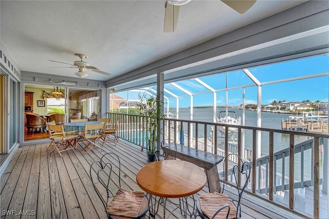 sunroom featuring ceiling fan, a water view, and plenty of natural light