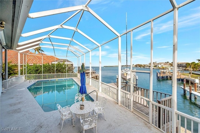 view of swimming pool featuring a dock, a patio, a water view, and glass enclosure