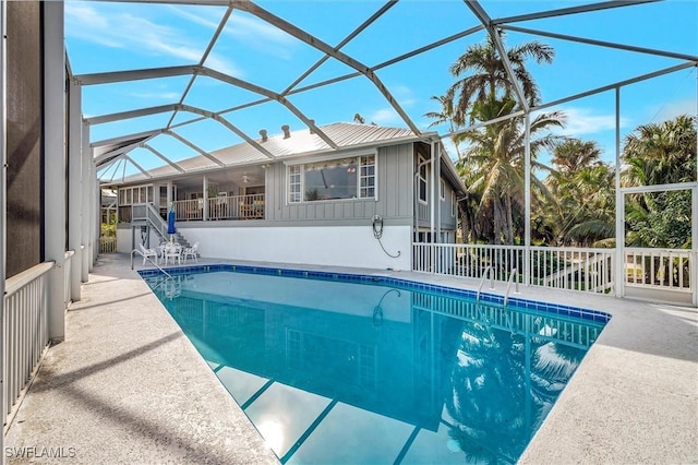 view of swimming pool featuring glass enclosure and a patio area