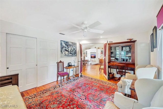 living room with ceiling fan and light wood-type flooring