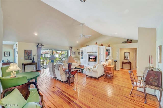 living room featuring ceiling fan, lofted ceiling, and light hardwood / wood-style flooring