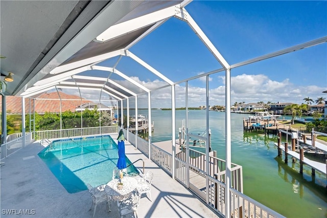 view of pool featuring a water view, a boat dock, glass enclosure, and a patio area