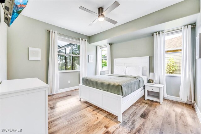 bedroom featuring multiple windows, ceiling fan, and light hardwood / wood-style flooring