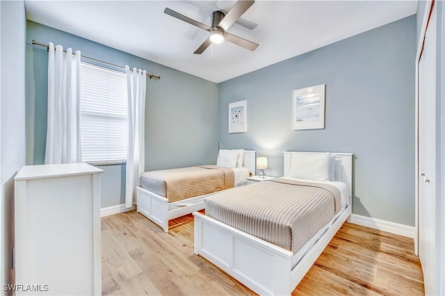 bedroom with ceiling fan, a closet, and light hardwood / wood-style flooring