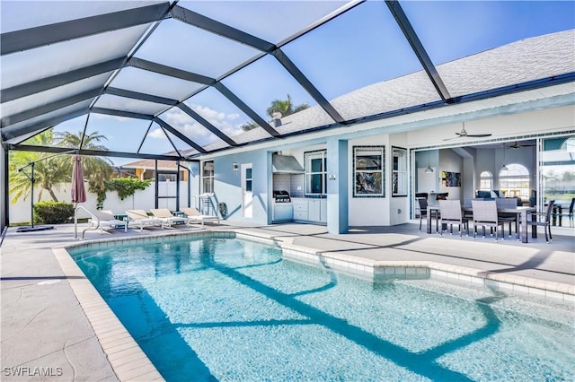 view of swimming pool with ceiling fan, exterior kitchen, and a patio