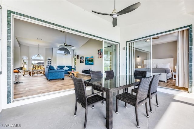 dining area featuring ceiling fan, concrete flooring, and lofted ceiling