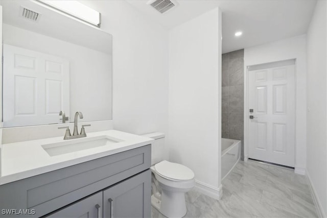 full bathroom with tiled shower / bath, vanity, and toilet