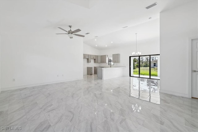 unfurnished living room featuring ceiling fan and high vaulted ceiling