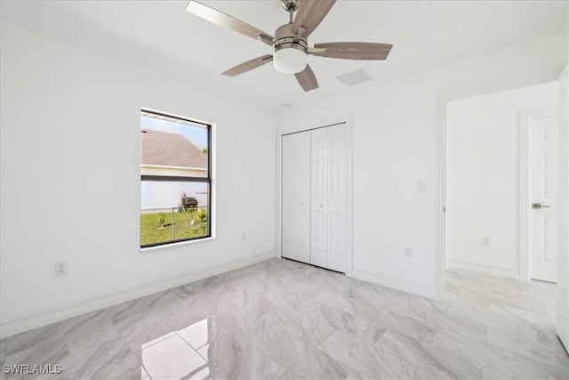 unfurnished bedroom featuring ceiling fan and a closet